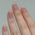 Close-up of a hand with pink glittery nail polish on a plain background, Obroi