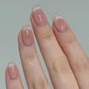 Close-up of a hand with pink glittery nail polish on a plain background, Obroi