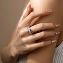 Close-up of a hand wearing a diamond ring on a neutral background, Obroi