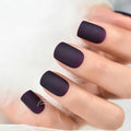 Close-up of a hand with dark purple nail polish on a neutral background, Obroi