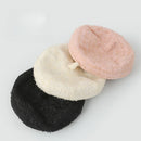 Three textured fabric beret-style hats stacked on a light gray background, shown in black, off-white, and pale pink, Obroi