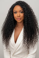 Woman with long, curly hair next to a set of black hair extensions, Obroi