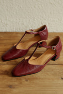 Pair of red high-heeled shoes on a wooden surface, Obroi