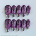 Purple nail art tips with black floral designs on a white background, Obroi