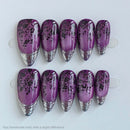 Purple nail art tips with black floral designs on a white background, Obroi