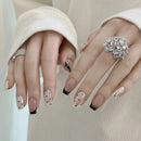 Close-up of hands with decorative nail art and rings on a neutral background, Obroi