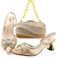 A women's formal shoe set with a matching rhinestone clutch bag, shown on a white background. The set includes a pair of pointed-toe mule heels in champagne satin with crystal embellishments, silver trim, and metallic gold cone heels, alongside a matching rectangular clutch with a yellow crystal bead handle, Obroi