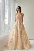 Woman wearing a floral beige evening gown in a softly lit room, Obroi