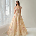 Woman wearing a floral beige evening gown in a softly lit room, Obroi