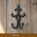 Decorative wall hook with intricate design on a wooden background, Obroi