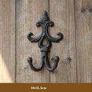 Decorative wall hook with intricate design on a wooden background, Obroi