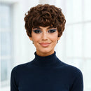 Woman with styled hair wearing a dark blue turtleneck against a blurred indoor background, Obroi