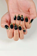 Hand with black and gold nail design on a white background, Obroi