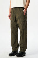 Person wearing olive green cargo pants on a white background, Obroi