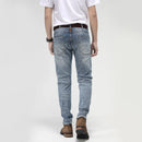 Person wearing light blue jeans on a white background, Obroi