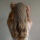 Person with long blonde hair wearing a decorative headpiece against a neutral background, Obroi
