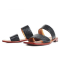 Black crocodile-patterned sandals with red soles on a white background, Obroi
