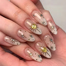 Nails with star and sun designs on a light background, Obroi