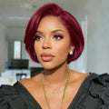 Woman with vibrant red hair wearing a black outfit and gold jewelry indoors, Obroi