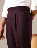 Maroon pleated pants worn by a person with a neutral background, Obroi