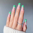 Obroi Hand with green and white nail design on a gray background