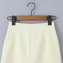 Light green skirt on a wooden hanger against a gray background, Obroi
