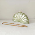 Shell-shaped clutch with a pearl on top and gold chain on a white background, Obroi