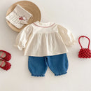 Children's outfit with white blouse, blue pants, and red shoes on a light background, Obroi