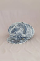 Denim cap with a brand logo on a beige background, Obroi