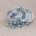 Denim cap with a brand logo on a beige background, Obroi