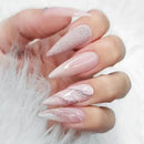 Obroi Hand with pink and white glittery nail design on a white background