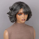 A short, wavy wig with dark gray and black tones, styled on a mannequin wearing a brown mock-neck top against a solid gray background, Obroi