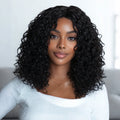 Woman with voluminous curly black hair wearing a light gray top, Obroi