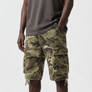 Person wearing camouflage cargo shorts on a white background, Obroi