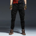 Person wearing black cargo pants and brown boots on a dark background, Obroi