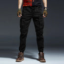 Person wearing black cargo pants and brown boots on a dark background, Obroi