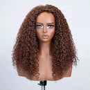 A long, voluminous brown curly wig displayed on a mannequin head against a plain light gray background, Obroi