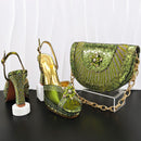 Green high-heeled shoes and matching handbag with rhinestone details on a black surface, Obroi