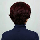 Person with short, dark burgundy hair wearing a navy turtleneck against a light background, Obroi