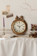Decorative clock on a table with a white tablecloth, candles, and flowers, Obroi