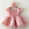 Pink children's dress with tulle layers and a matching headband on a white background, Obroi