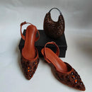 Brown high-heeled shoes with embellishments and a matching handbag on a white background, Obroi