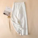 White pants on a beige background with a magazine and dried plant, Obroi