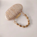 Marbled clutch with a gold chain and beige beads on a light gray background, Obroi