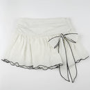 White polka dot skirt with a blue ribbon on a white background, Obroi