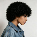 Woman with curly hair wearing a denim jacket against a neutral background, Obroi