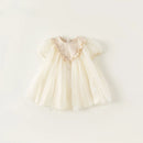 Cream-colored baby dress with ruffled details on a white background, Obroi