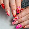 Close-up of hands with colorful nail art featuring hearts and swirls, Obroi