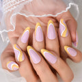 Nails with pink and yellow design held by a person wearing a white lace garment, Obroi