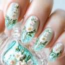 Obroi Nails with floral design in light blue and white on a white background